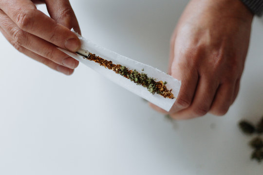 Male hands rolling a joint - horizontal
