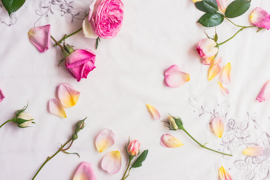 background roses scattered on a vintage embroidered linen tablecloth