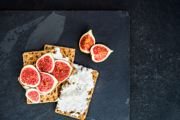 Healthy snack from wholegrain rye crispbread crackers, figs and ricotta cheese