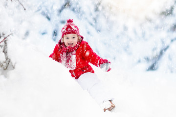 Child playing with snow in winter.Boy in snowy park.