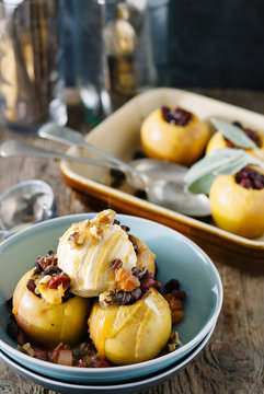 Baked apple dessert on table, being drizzled with toffee sauce.