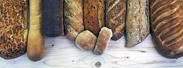 Assorted bread loaves, buns, rolls and bakery - panorama / banner.