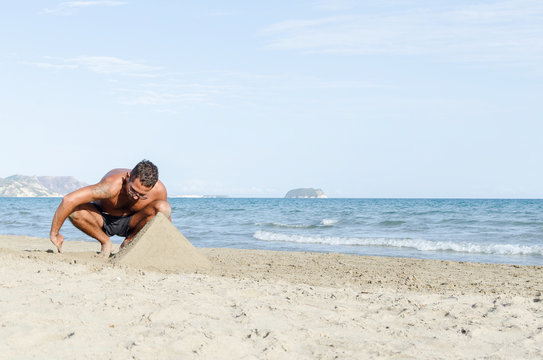 Man making pyramind from sand