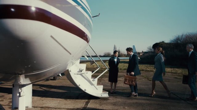  International business team boarding private plane on the runway
