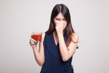 Young Asian woman hate tomato juice.