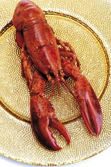 A whole boiled lobster on a golden plate