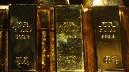  Close up gold bars on shimmering rotating stand, wealth & luxury concept.