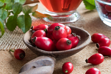Fresh rose hips on a wooden spoon