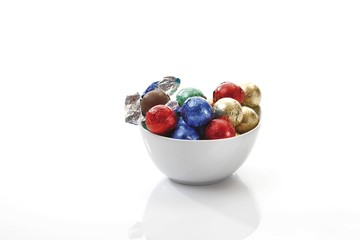 Small porcelain bowl with chocolate balls in coloured wrapping