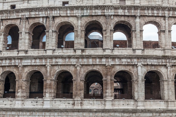 Obraz premium a fragment of Colosseum ruins in Rome with trees on a sunny summer day