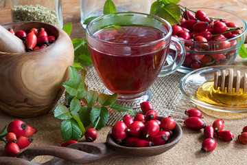 A cup of rose hip tea with fresh rose hips