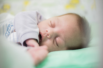Baby boy sleeping in crib - Closeup