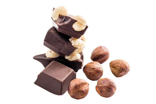 Pieces of bitter dark chocolate cubes with hazelnut isolated on white background