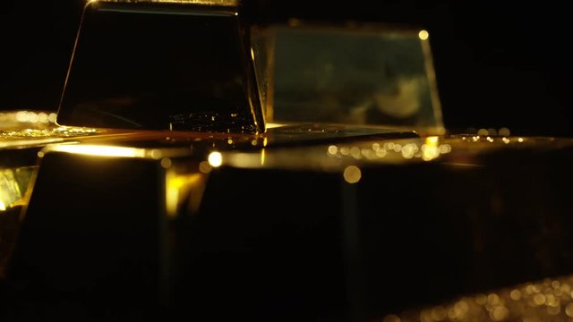  Close up gold bars on shimmering rotating stand, wealth & luxury concept.