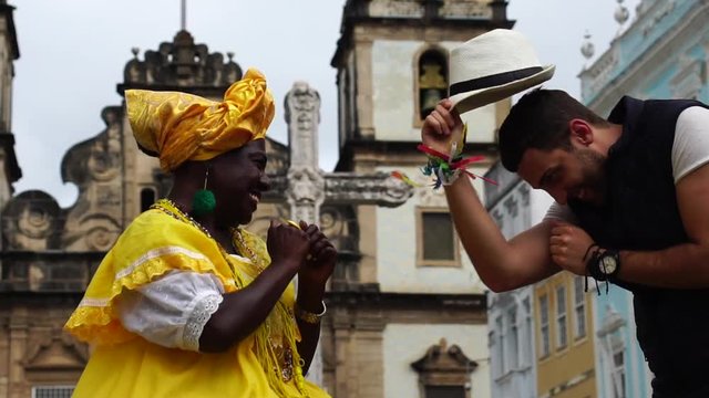 Tourist Dancing Throw his hat for Native Woman Brazilian People - "Baiana" in Salvador, Bahia