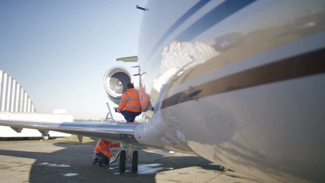  Maintenance engineers servicing a plane on airfield