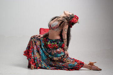 A traditional dance dancer dressed in a gypsy costume and posing in the studio performing dance moves