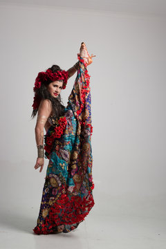 A traditional dance dancer dressed in a gypsy costume and posing in the studio performing dance moves