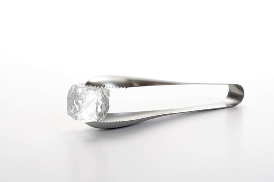 Ice cube tongs holding an ice cube