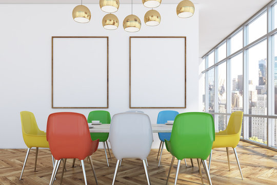 Dining room with colorful chairs, two posters