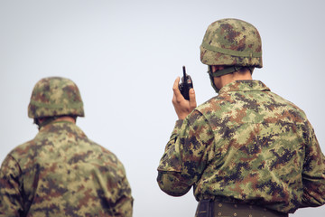 Soldiers in action communicating on walkie talkie