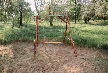 A wooden swing in the park. Eco-friendly materials in green environment