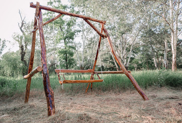 A wooden swing in the park. Eco-friendly materials in green environment