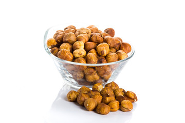Fototapeta na wymiar Group of peeled hazelnuts in a bowl on a white background