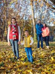 Fototapeta premium Happy family walking in autumn park