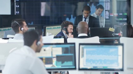  Financial trader in busy stock exchange celebrates making a successful deal