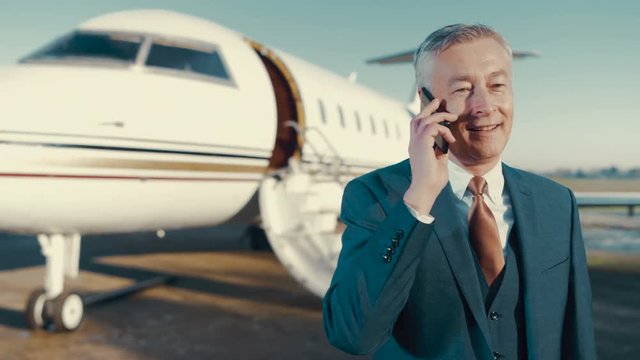  Portrait VIP businessman talking on phone before boarding private jet