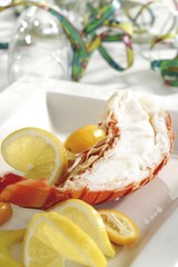 Cooked half langouste with kumquats and lemon slices