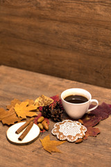Fall coffee with cinnamon, mandel and gingerbread on the wooden backgound