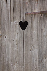 Ausgesägtes Herz an einer Toilettentür aus Holz