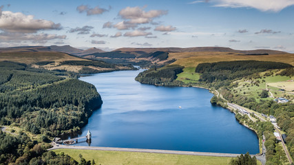 Aerial view of a reservoir and dam wall surrounded by forest
