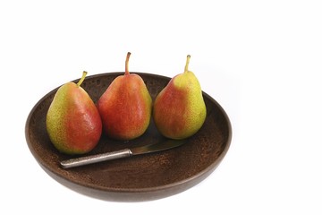 Three pears with a fruit knife in a fruit bowl