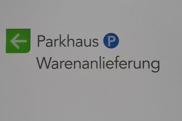 Beschilderung mit dem Hinweis zu einem Parkhaus und zur Warenanlieferung