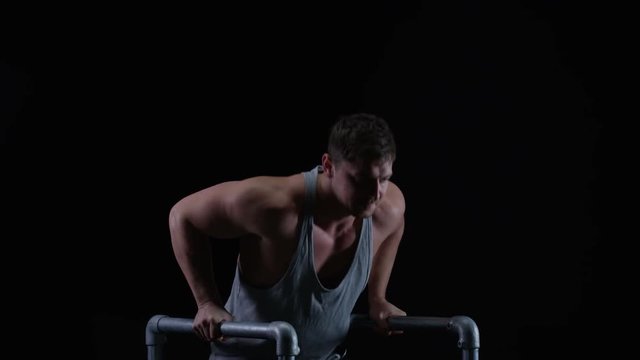  Muscular man working out with gym equipment against a black background