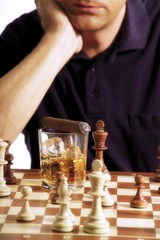 Chess player playing a game of chess, a glass of whisky and a cigar