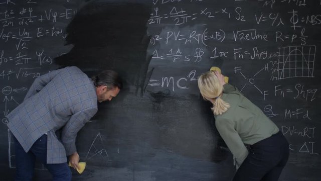  Time lapse man & woman cleaning off chalkboard to leave blank copy space