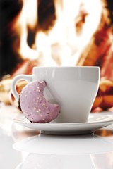 Coffee cup and half-moon shaped gingerbread cookie, chimney fire at back