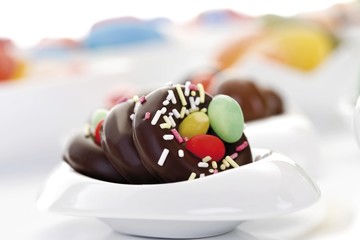 Variety of candy easter eggs and sweets in porcelain bowls