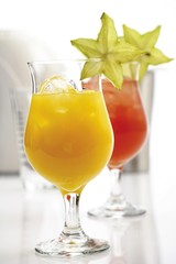 Two cocktails: orange - and strawberry daiquiris garnished with starfruit