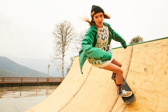 A girl doing skateboarding on a ramp on a rainy weather