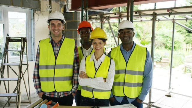  Portrait smiling team of architects & engineers at construction site