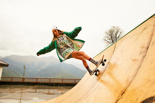 A girl doing skateboarding on a ramp on a rainy weather