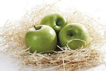 Green apples in wood shavings