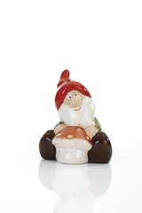 Garden gnome sitting behind a mushroom