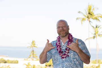 Adult man on Hawaiian vacation wearing a fresh orchid lei