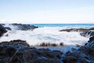 Motion blur of ocean waves crashing on rocks
